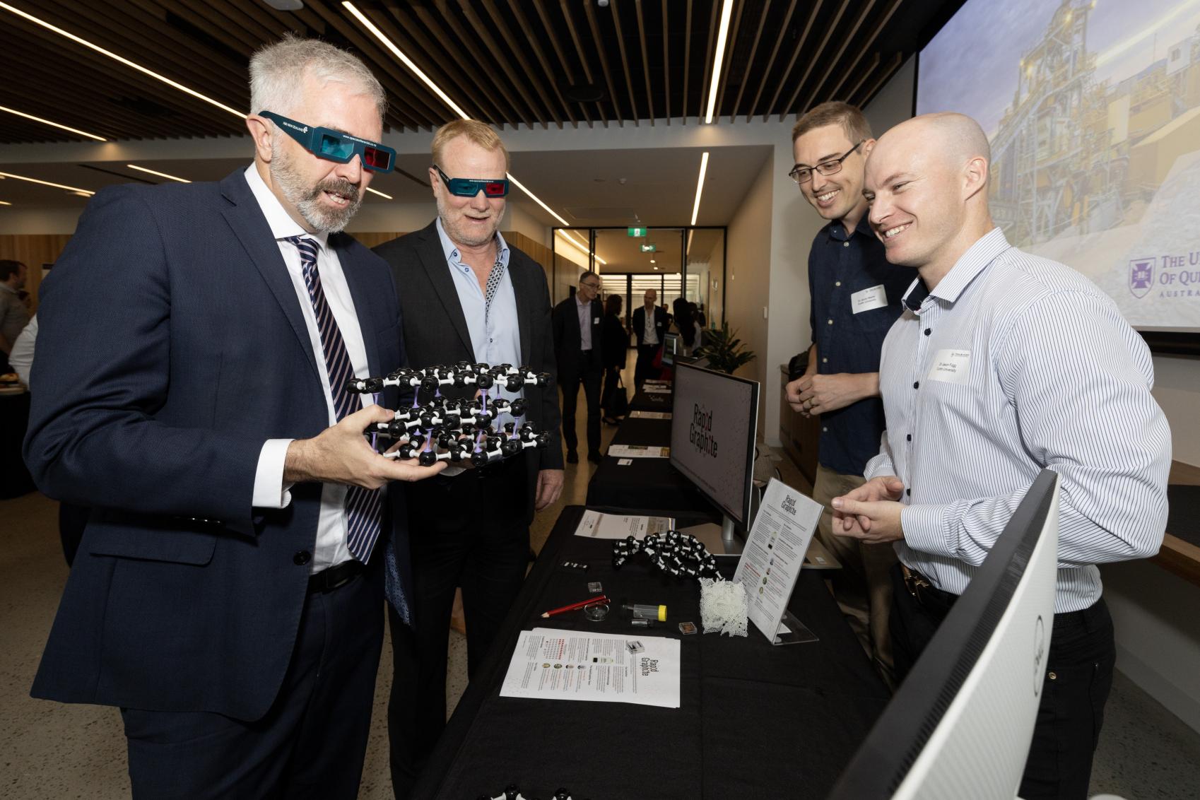 Assistant Minister for Education and Regional Development, Anthony Chisholm and 3 people looking at a product together